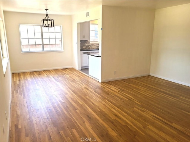 12817 Larwin Rd, Norwalk, CA 90650 - unfurnished room with dark wood-type flooring and a chandelier