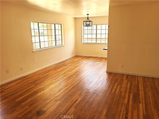 12817 Larwin Rd, Norwalk, CA 90650 - empty room with plenty of natural light, wood finished floors, and a chandelier