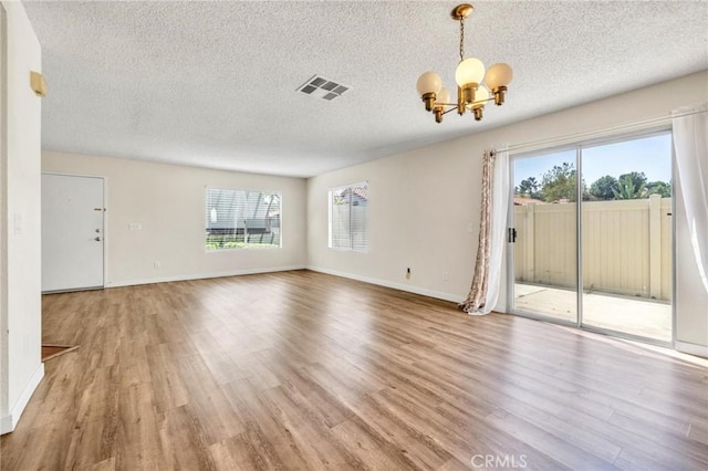 24232 Sylvan Glen Rd Unit A, Diamond Bar, CA 91765 - unfurnished living room with a chandelier, wood finished floors, plenty of natural light, and a textured ceiling