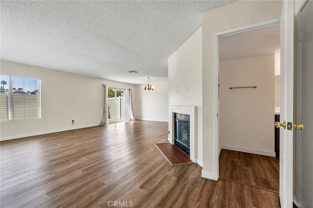 24232 Sylvan Glen Rd Unit A, Diamond Bar, CA 91765 - unfurnished living room featuring wood finished floors, a chandelier, a textured ceiling, and a glass covered fireplace