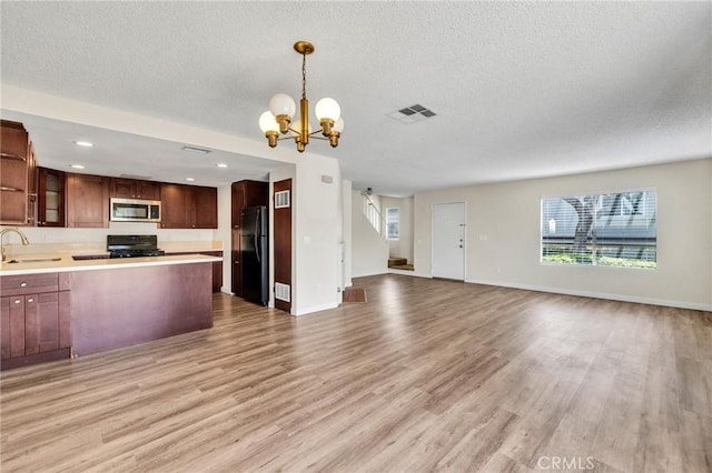 24232 Sylvan Glen Rd Unit A, Diamond Bar, CA 91765 - kitchen featuring stainless steel microwave, freestanding refrigerator, open floor plan, a chandelier, and range
