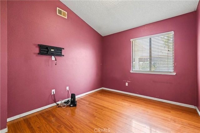 37702 Medea Ct, Palmdale, CA 93550 - empty room featuring wood finished floors, vaulted ceiling, and a textured ceiling