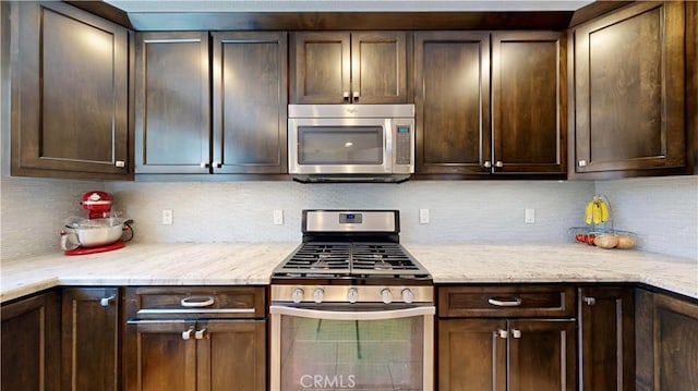 7413 Crimson Dr, Highland, CA 92346 - kitchen featuring appliances with stainless steel finishes, dark brown cabinets, and tasteful backsplash
