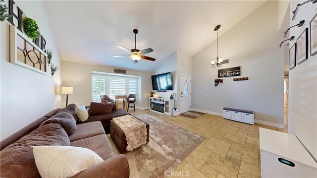 7413 Crimson Dr, Highland, CA 92346 - living room featuring stone tile floors, a ceiling fan, high vaulted ceiling, and a chandelier