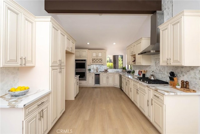 16066 Rancho Verde Cir, Riverside, CA 92506 - kitchen with wall chimney range hood, stainless steel appliances, tasteful backsplash, cream cabinetry, and recessed lighting