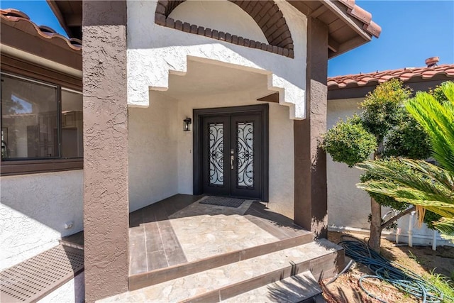 16066 Rancho Verde Cir, Riverside, CA 92506 - view of exterior entry featuring french doors, stucco siding, and a tile roof