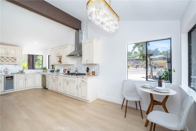 16066 Rancho Verde Cir, Riverside, CA 92506 - kitchen featuring wall chimney range hood, wine cooler, stainless steel appliances, tasteful backsplash, and light countertops
