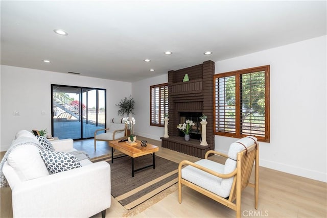 16066 Rancho Verde Cir, Riverside, CA 92506 - living room featuring healthy amount of natural light, a fireplace, recessed lighting, and light wood finished floors