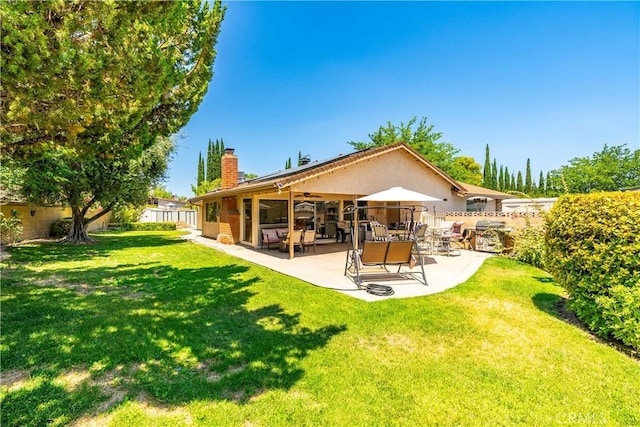 2608 Nice Ct, Lancaster, CA 93536 - rear view of house with a chimney, ceiling fan, a fenced backyard, and a patio
