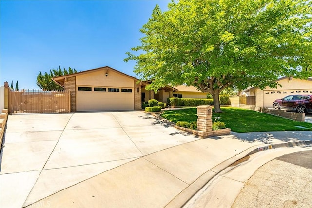 2608 Nice Ct, Lancaster, CA 93536 - view of front facade with a garage, driveway, brick siding, stucco siding, and a gate
