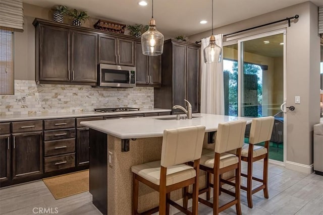 1170 Spring Azure Way Unit 45, Nipomo, CA 93444 - kitchen featuring stainless steel appliances, decorative backsplash, a breakfast bar, light countertops, and dark brown cabinetry