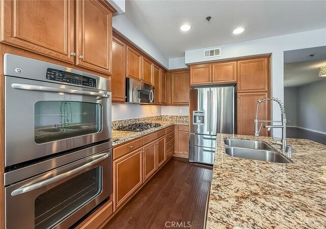 374 E Hilltop Way, Thousand Oaks, CA 91362 - kitchen with appliances with stainless steel finishes, brown cabinetry, light stone counters, dark wood-style flooring, and recessed lighting