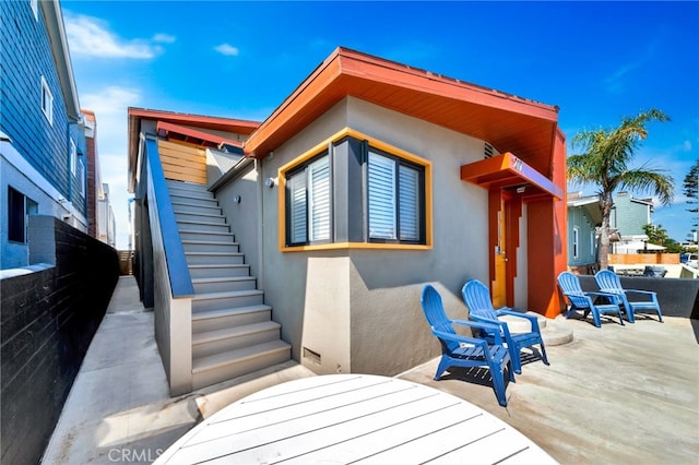 217 E Balboa Blvd, Newport Beach, CA 92661 - back of property featuring stairs, stucco siding, and a patio area