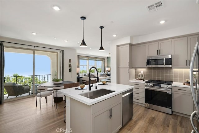 12247 Elliott Ave Unit F, El Monte, CA 91732 - kitchen with appliances with stainless steel finishes, gray cabinetry, dark wood finished floors, decorative backsplash, and recessed lighting