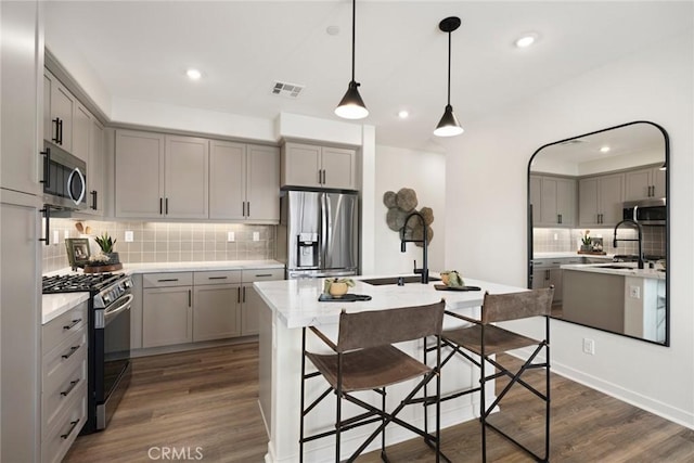 12247 Elliott Ave Unit F, El Monte, CA 91732 - kitchen with stainless steel appliances, gray cabinets, backsplash, an island with sink, and recessed lighting