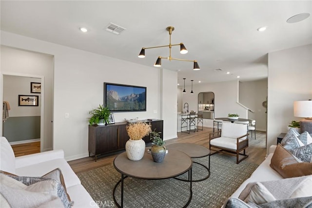 12247 Elliott Ave Unit F, El Monte, CA 91732 - living area with wood finished floors, a chandelier, arched walkways, and recessed lighting