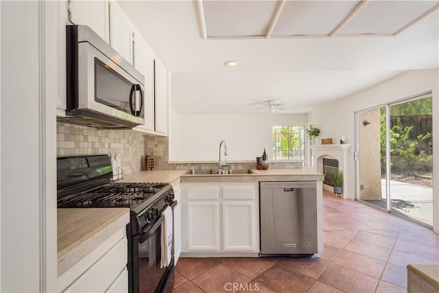24249 Saradella Ct, Murrieta, CA 92562 - kitchen featuring appliances with stainless steel finishes, a peninsula, tasteful backsplash, white cabinets, and light countertops