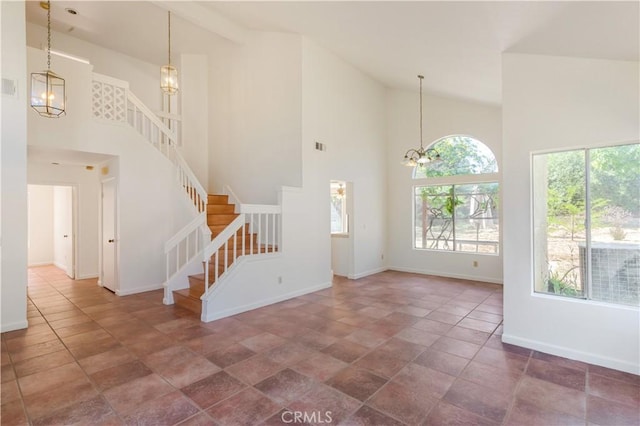 24249 Saradella Ct, Murrieta, CA 92562 - unfurnished living room featuring a chandelier, high vaulted ceiling, healthy amount of natural light, stairs, and stone finish flooring