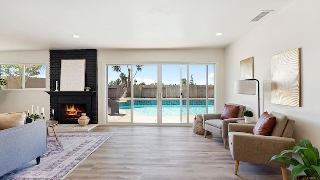 8865 Highsmith Ln, San Diego, CA 92119 - living room featuring light wood finished floors, recessed lighting, and a fireplace