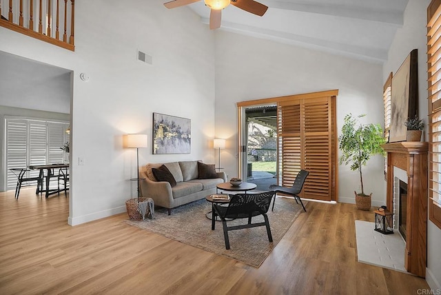 1930 Rosewood St, Vista, CA 92081 - living area with a ceiling fan, wood finished floors, high vaulted ceiling, beamed ceiling, and a tiled fireplace