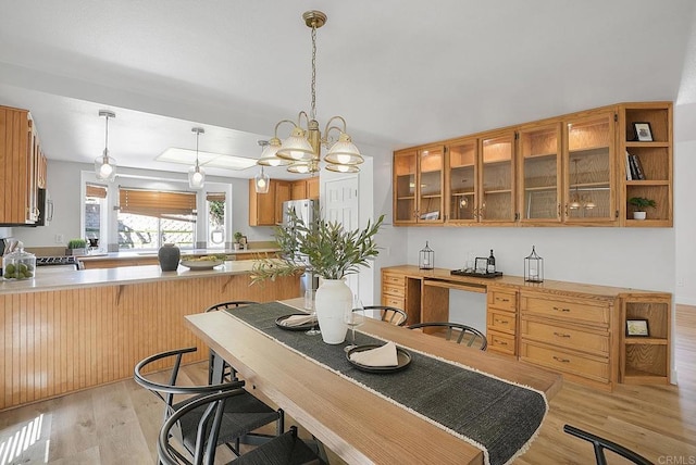 1930 Rosewood St, Vista, CA 92081 - kitchen featuring light wood-type flooring, light countertops, a peninsula, and glass insert cabinets