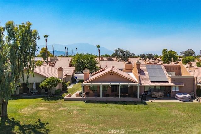 42386 Sultan Ave, Palm Desert, CA 92211 - rear view of house with roof mounted solar panels, a mountain view, a yard, a sunroom, and a residential view