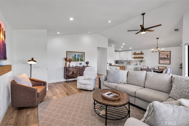 42386 Sultan Ave, Palm Desert, CA 92211 - living room featuring light wood-style floors, vaulted ceiling, a ceiling fan, a chandelier, and recessed lighting