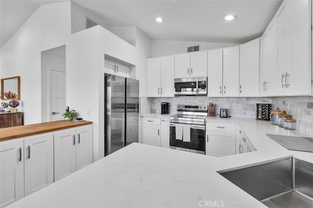 42386 Sultan Ave, Palm Desert, CA 92211 - kitchen featuring appliances with stainless steel finishes, vaulted ceiling, decorative backsplash, white cabinets, and recessed lighting