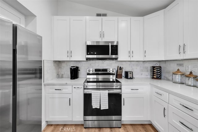 42386 Sultan Ave, Palm Desert, CA 92211 - kitchen featuring stainless steel appliances, lofted ceiling, light countertops, decorative backsplash, and white cabinets