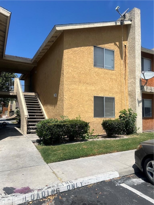 1025 N Tippecanoe Ave Unit 238, San Bernardino, CA 92410 - view of side of home with stucco siding and stairway