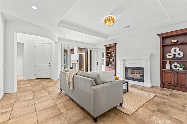 31521 Paseo Campeon, San Juan Capistrano, CA 92675 - living area featuring a glass covered fireplace, a tray ceiling, light tile patterned floors, and recessed lighting