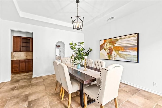 31521 Paseo Campeon, San Juan Capistrano, CA 92675 - dining space with arched walkways, a raised ceiling, light tile patterned floors, and a chandelier
