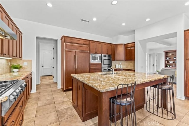 31521 Paseo Campeon, San Juan Capistrano, CA 92675 - kitchen featuring built in appliances, a kitchen island with sink, tasteful backsplash, light stone counters, and recessed lighting
