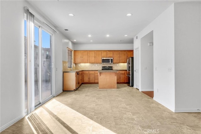 4564 Vincent Way, Riverside, CA 92501 - kitchen featuring appliances with stainless steel finishes, tasteful backsplash, a center island, and recessed lighting
