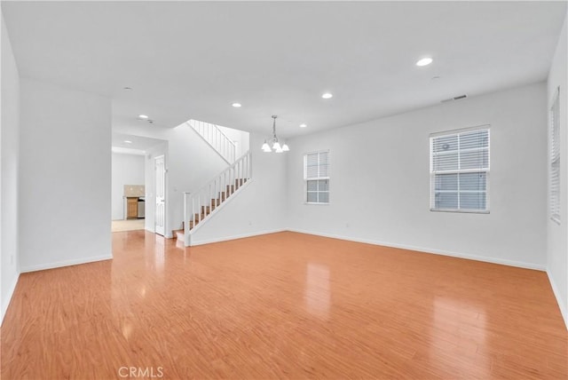 4564 Vincent Way, Riverside, CA 92501 - unfurnished living room featuring light wood-style floors, a chandelier, stairway, and recessed lighting