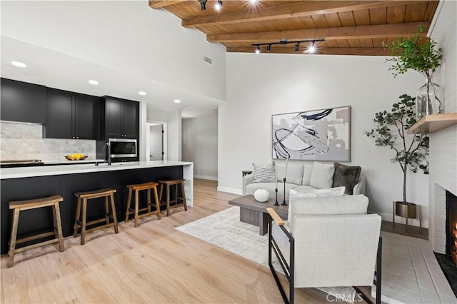 9712 Saloma Ave, North Hills, CA 91343 - living area featuring a wood ceiling with exposed beams, light wood-style flooring, and a fireplace