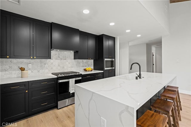 9712 Saloma Ave, North Hills, CA 91343 - kitchen with stainless steel appliances, dark cabinets, range hood, light wood-type flooring, and recessed lighting