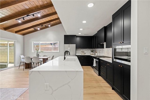 9712 Saloma Ave, North Hills, CA 91343 - kitchen with stainless steel appliances, dark cabinetry, wooden ceiling, light stone counters, and backsplash