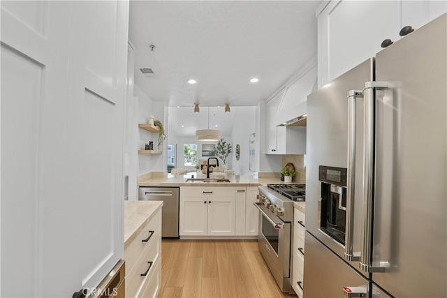 2000 Pacific Coast Hwy Unit 313, Huntington Beach, CA 92649 - kitchen featuring high quality appliances, light wood-type flooring, light countertops, white cabinetry, and recessed lighting