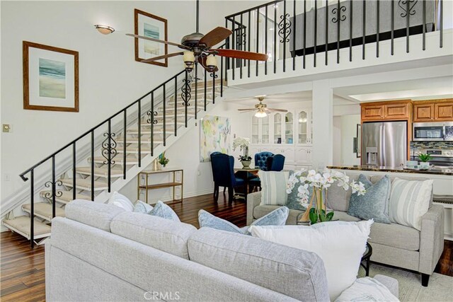 2164 Via Mariposa E Unit D, Laguna Woods, CA 92637 - living room featuring a ceiling fan, wood finished floors, stairs, and a towering ceiling