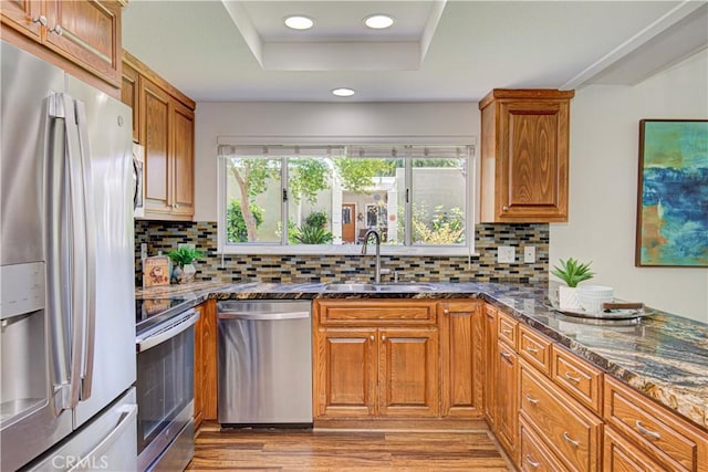 2164 Via Mariposa E Unit D, Laguna Woods, CA 92637 - kitchen featuring appliances with stainless steel finishes, brown cabinets, dark stone counters, recessed lighting, and a tray ceiling