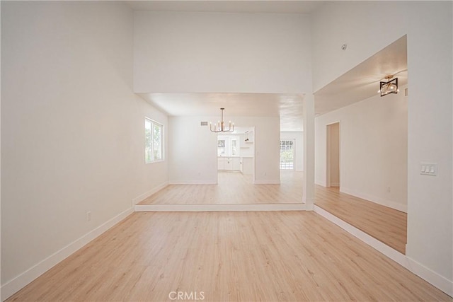 812 San Juan Ln, Placentia, CA 92870 - spare room featuring a chandelier, a towering ceiling, light wood-style flooring, and healthy amount of natural light