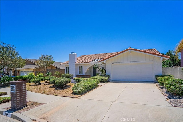 812 San Juan Ln, Placentia, CA 92870 - view of front of house featuring a tile roof, an attached garage, driveway, a chimney, and stucco siding