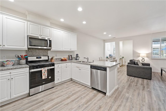 2848 E Berry Loop Privado Unit 52, Ontario, CA 91761 - kitchen with stainless steel appliances, a peninsula, light wood-style floors, open floor plan, and recessed lighting
