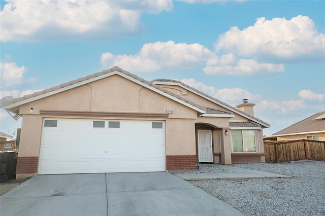 15460 Guava Way, Victorville, CA 92394 - view of front facade featuring brick siding, concrete driveway, a garage, and a chimney