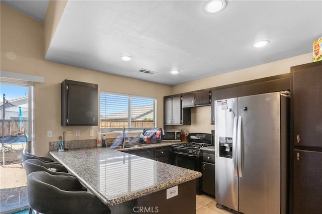 15460 Guava Way, Victorville, CA 92394 - kitchen with appliances with stainless steel finishes, a peninsula, recessed lighting, stone countertops, and light tile patterned floors