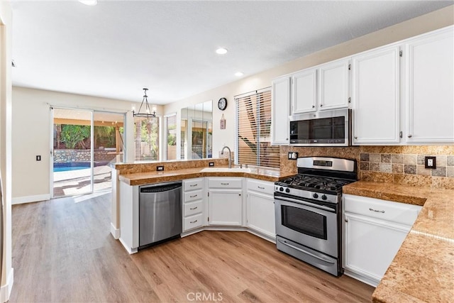 4441 Foxrun Dr, Chino Hills, CA 91709 - kitchen featuring stainless steel appliances, a peninsula, white cabinetry, light wood-style floors, and recessed lighting