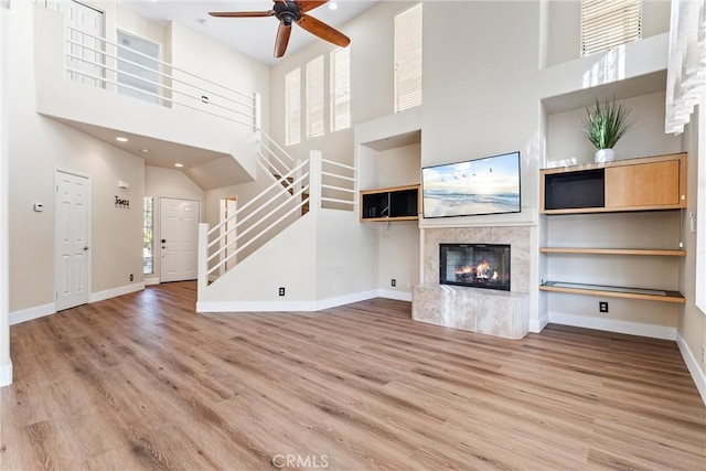4441 Foxrun Dr, Chino Hills, CA 91709 - unfurnished living room featuring a high ceiling, stairs, a high end fireplace, ceiling fan, and wood finished floors