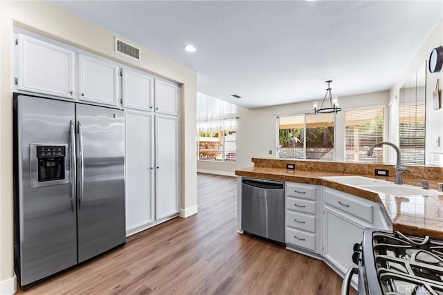 4441 Foxrun Dr, Chino Hills, CA 91709 - kitchen with stainless steel appliances, a chandelier, light wood finished floors, white cabinetry, and recessed lighting