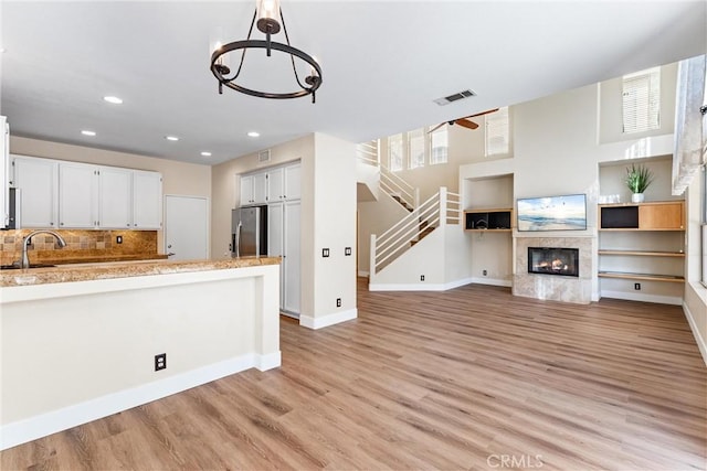 4441 Foxrun Dr, Chino Hills, CA 91709 - kitchen featuring stainless steel refrigerator with ice dispenser, light wood finished floors, open floor plan, recessed lighting, and a peninsula